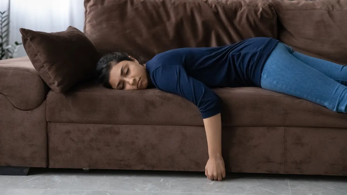 Person lying exhausted on a couch