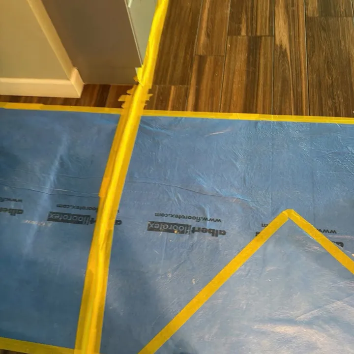 Taped floor protection covering wood plank flooring to prevent damage during restoration work in Papillion