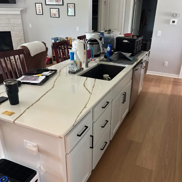 Kitchen island with sink and dishwasher above clean wood flooring after a water damage repair in Omaha