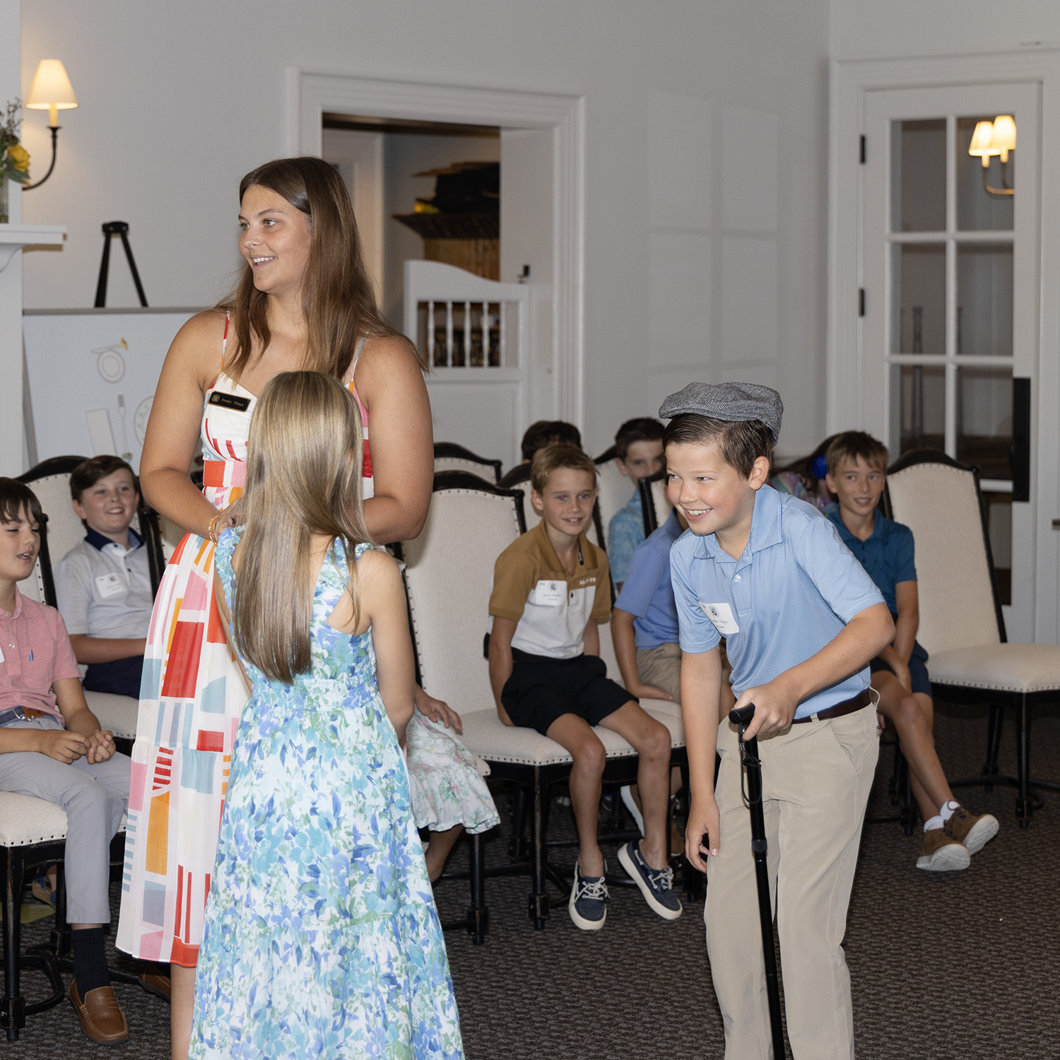 Young gentlemen pretending to be an old man and being introduced to a young lady who is pretending to be the President they are laughing and having fun while learning manners and etiquette NLJC Nashville Williamson County Chapters