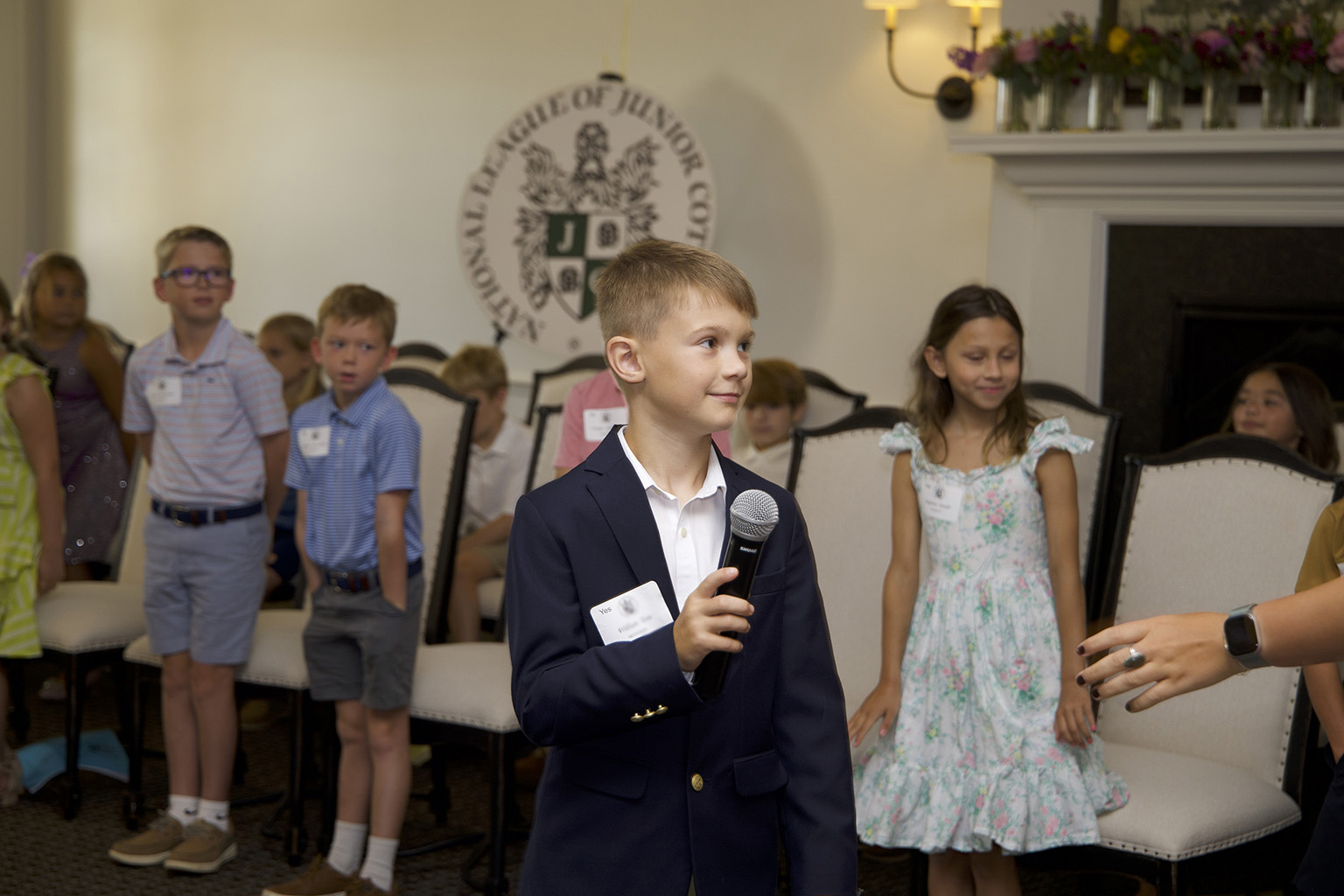Young gentlemen smiling and speaking in front of a group of parents during graduation  Pre-Cotillion NLJC Manners Classes Nashville, TN grades 1-5 manners classes 