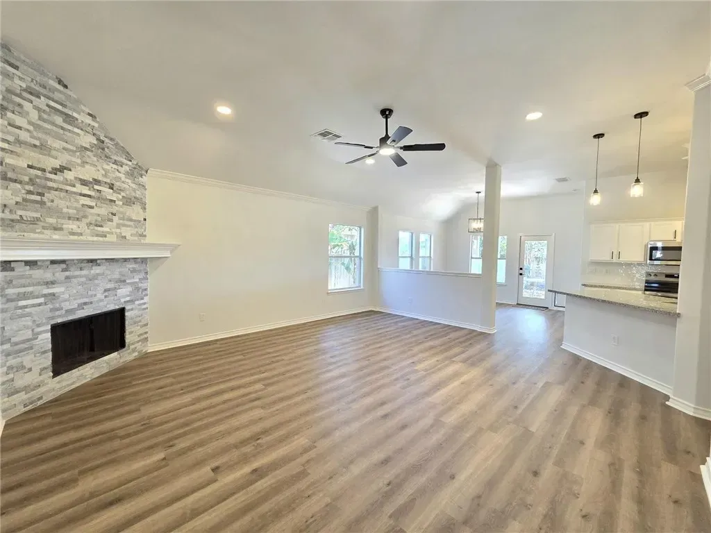 An elegant master bedroom featuring a king-size bed with coastal-inspired decor, soft blue accents, and large windows overlooking a lush backyard. The room is bright, airy, and designed for relaxation in a Corpus Christi home.