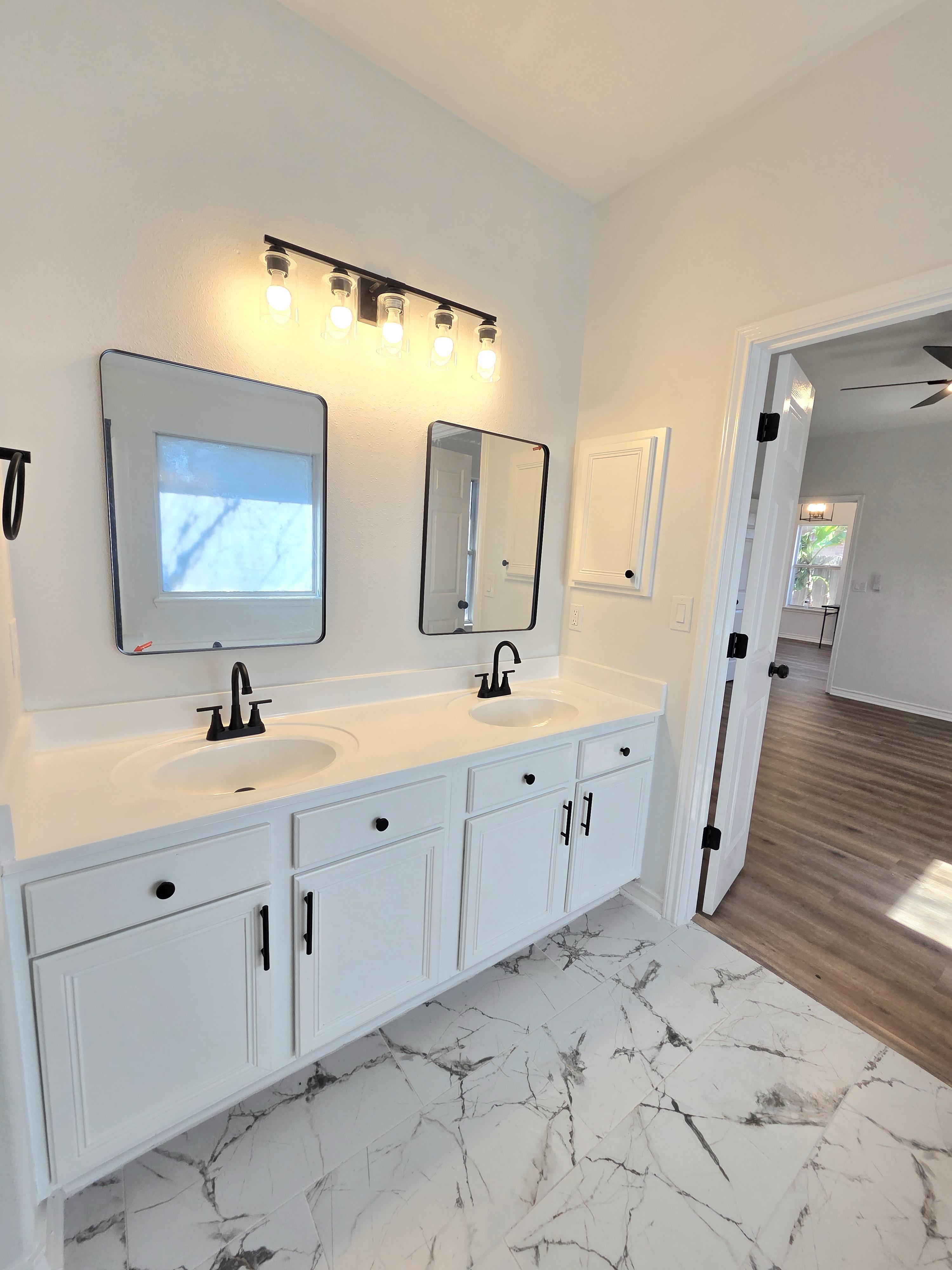 Serene master bedroom with a king-sized bed, soft linens, and a private balcony overlooking lush gardens. The room features calming colors and modern decor, creating a peaceful retreat in Corpus Christi.