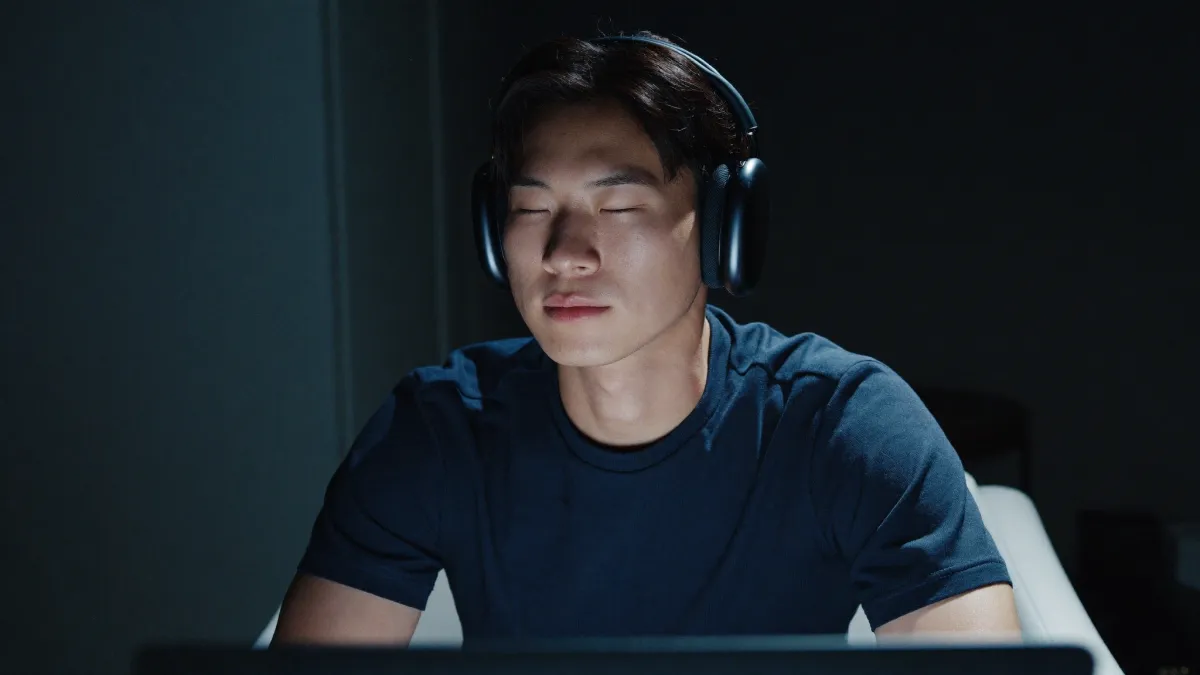 Athlete in a private online reconditioning session, headphones on, eyes closed