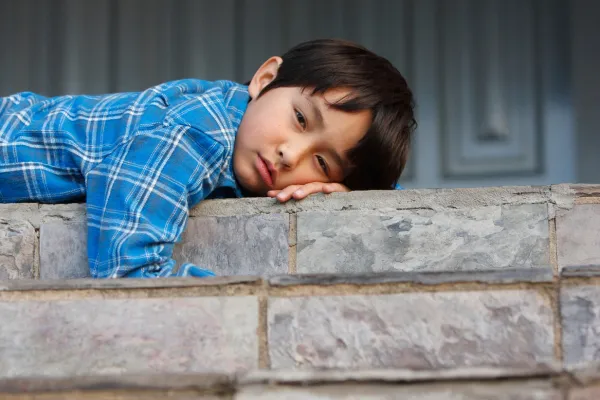 child-sleeping-on-a-brick-wall