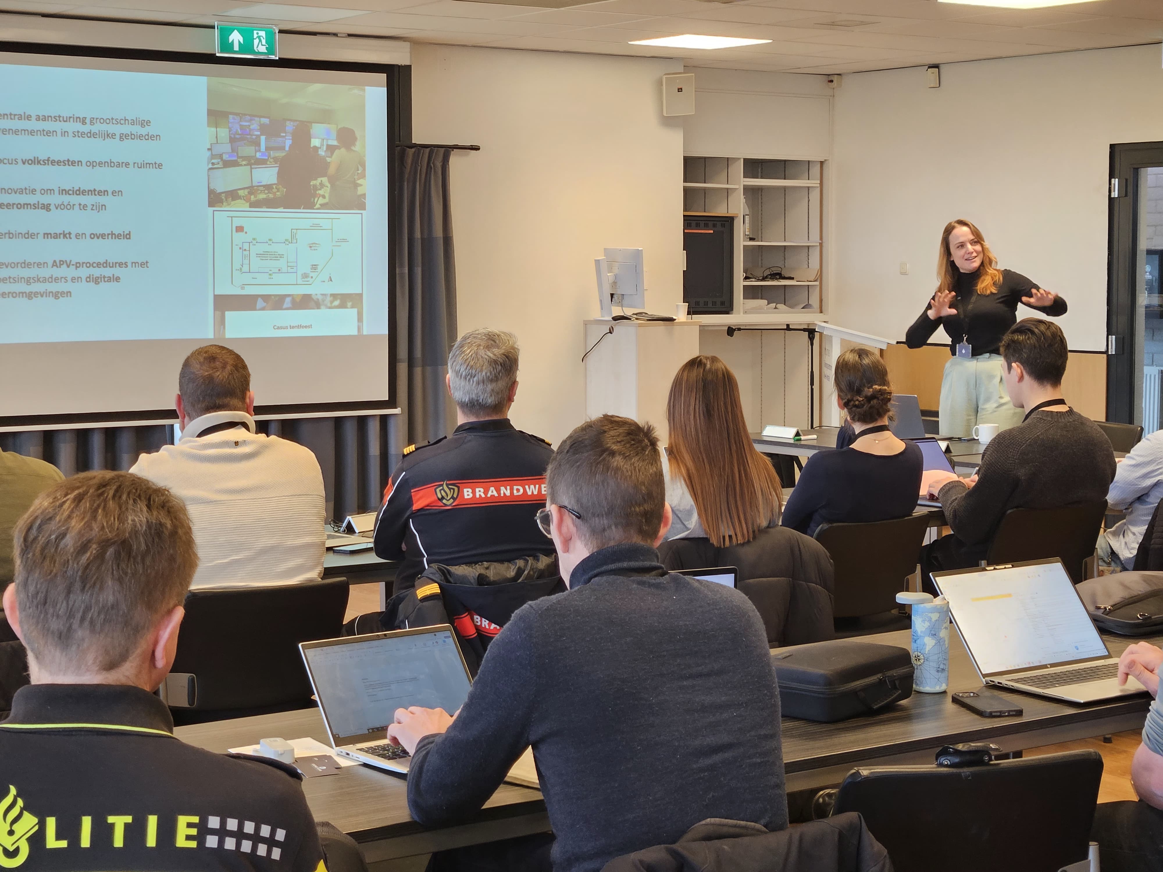 A woman sits at a desk with a laptop.