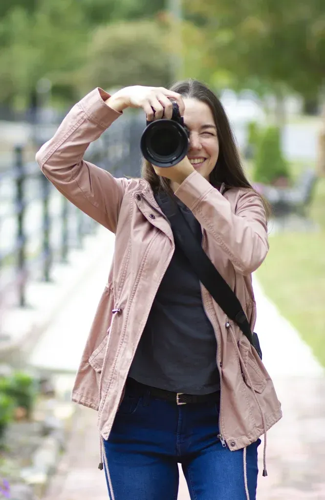 Videographer holding a professional camera outdoors, ready to film an event
