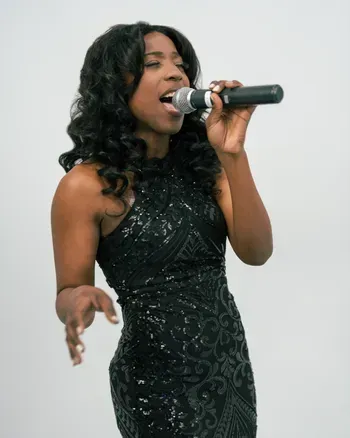 Vocalist performing with microphone in a black sequin dress