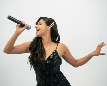 Female vocalist singing into microphone in a sparkle dress