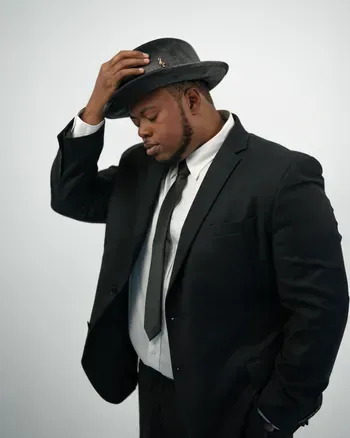 Male vocalist in black suit and hat with microphone