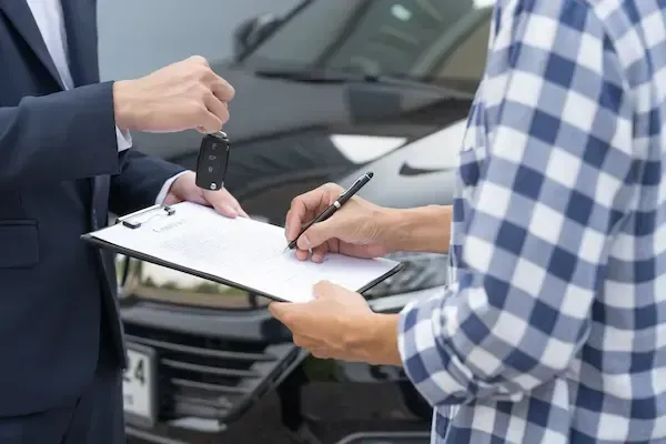 Driving instructor handing car keys to student during road test preparation at Adventure Driving School in Paterson, NJ.