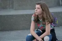 Smiling Hawthorne student Maya holding her learner certificate.