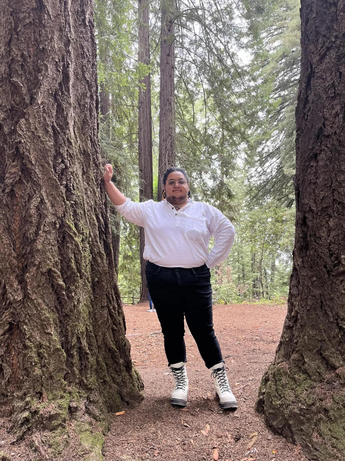 A circular picture of Hunter Archield-Cupit in between two redwood trees.