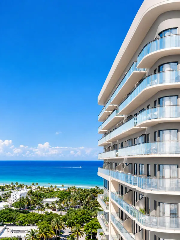Vista al océano Atlántico desde NoBe PARC en Miami Beach, Florida, con balcones modernos de vidrio, arquitectura de lujo y paisaje tropical frente al mar.