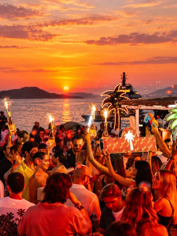 Fiesta exclusiva frente al mar al atardecer, con música, celebración y ambiente tropical que refleja el estilo de vida de lujo en Miami