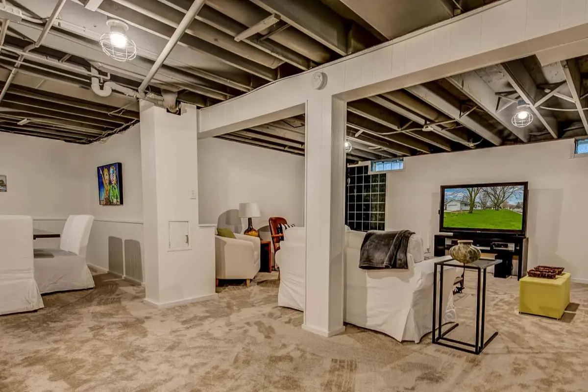 Remodeled Myrtle Beach basement with hardwood floors, recessed lighting, cozy seating, flat-screen TV, coastal decor, wet bar, and large windows.