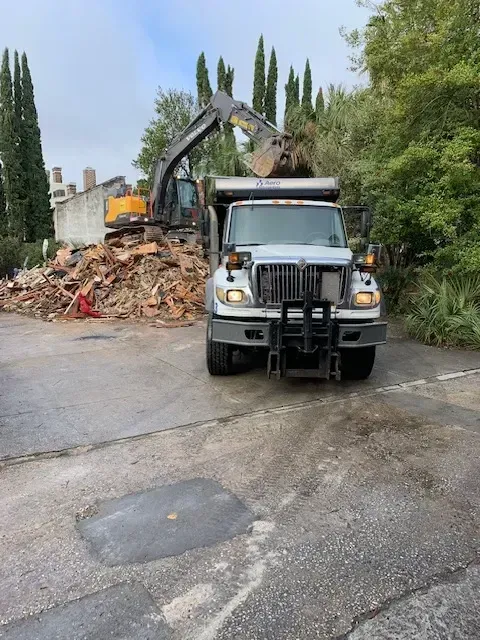 Cleared Myrtle Beach lot after house demolition with exposed foundation, neat debris removal, and landscaping ready for new construction