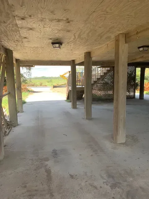 Completed Myrtle Beach garage demolition site with exposed foundation, debris cleared, coastal background, bright sunlight, professional cleanup