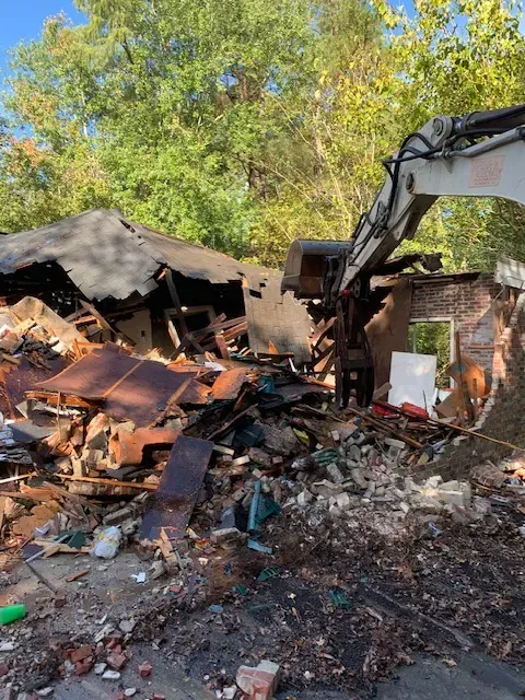 Demolition site in Myrtle Beach SC, featuring cleared lot, debris piles, coastal scenery, and safety barriers.