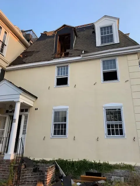 Demolition site in Charleston SC featuring a cleared lot with organized debris and construction equipment in a suburban setting.