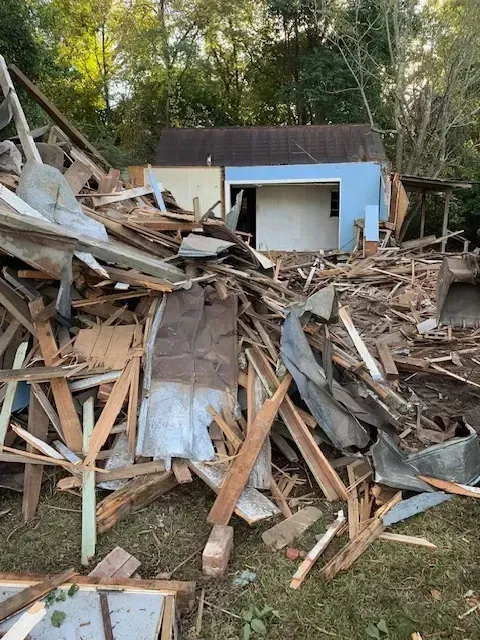 Demolished Myrtle Beach house with exposed beams, bricks, debris, palm trees, safety fencing, detailed textures, and bright sky
