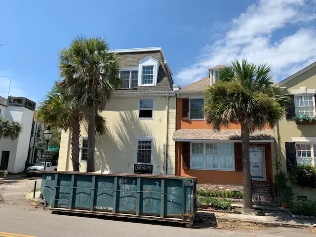 Demolition site in Columbia SC with organized debris, brick remnants, construction barriers, and clear blue sky.