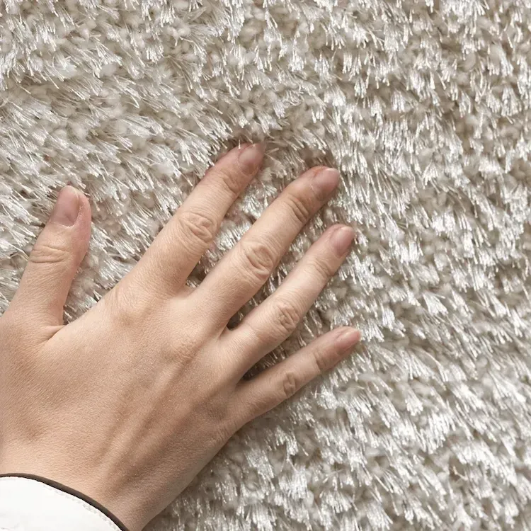 Hand touching clean carpet after professional deep cleaning service