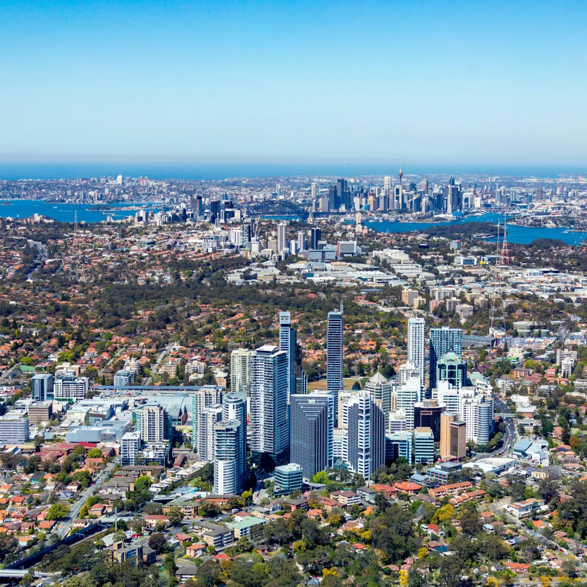 Aerial view of Chatswood with Sydney CBD in the distance, showcasing commercial and residential areas serviced by High Demand Restoration for flood, mould, and water damage recovery.