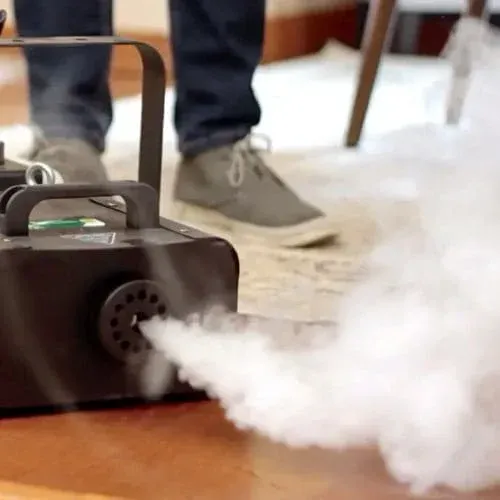 Technician using fogging machine to treat mould and disinfect surfaces.