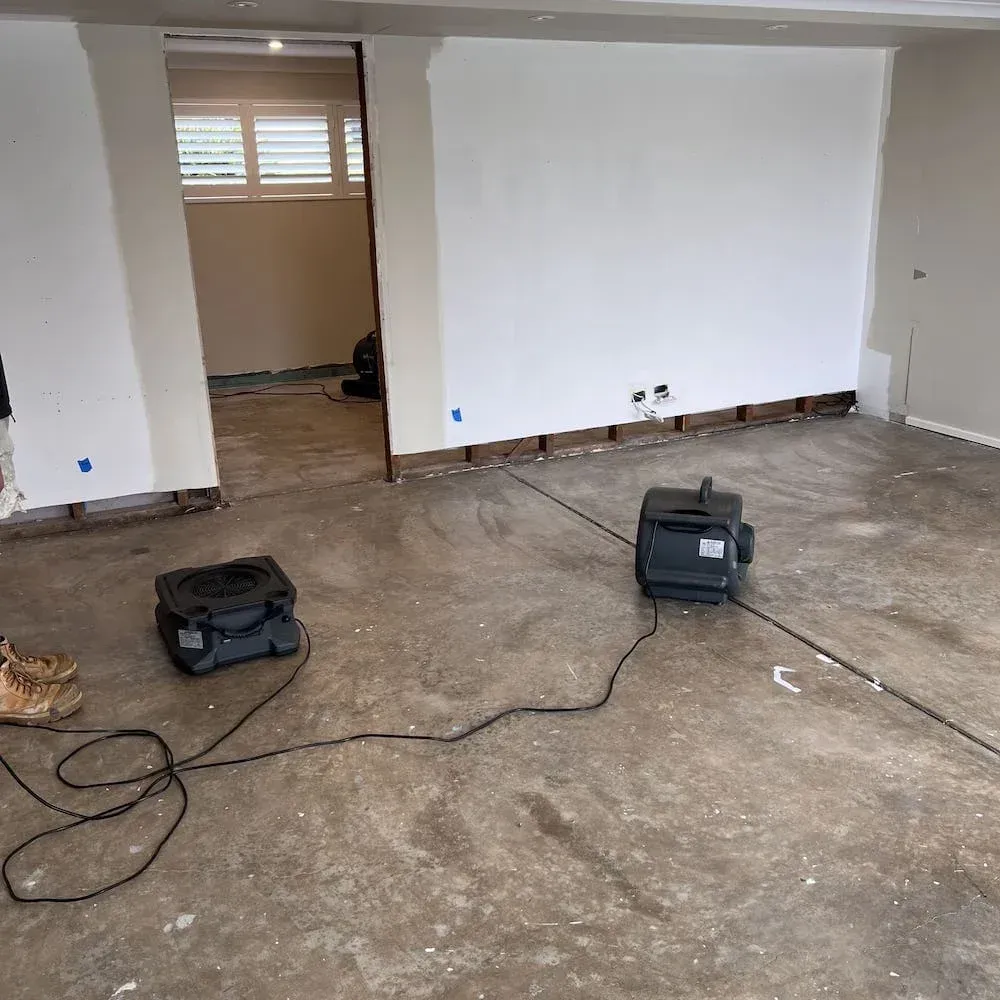 Industrial air movers drying a flood-affected room to prevent mould growth.