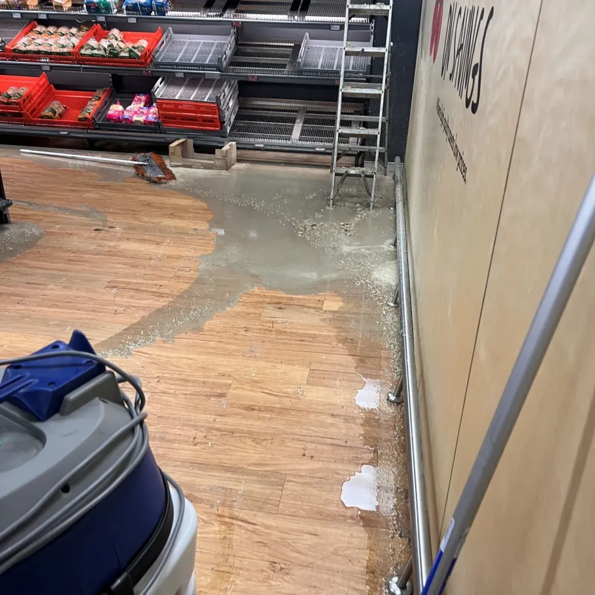 Commercial shop floor affected by grease trap overflow before professional cleanup and restoration.