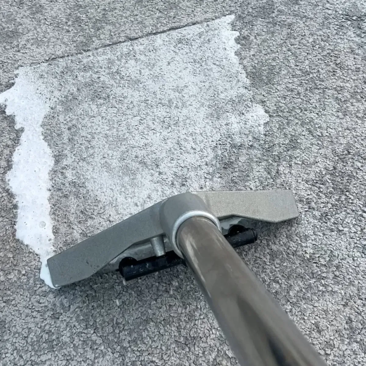 Carpet cleaning tool removing dirt and moisture from flooring surface.