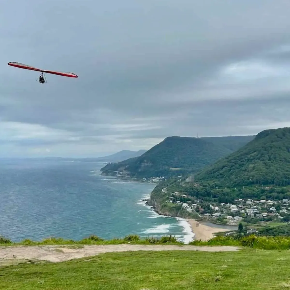 Hang glider over Stanwell Park and the Illawarra escarpment, showcasing High Demand Restoration’s extensive reach throughout coastal NSW for flood and water damage response.