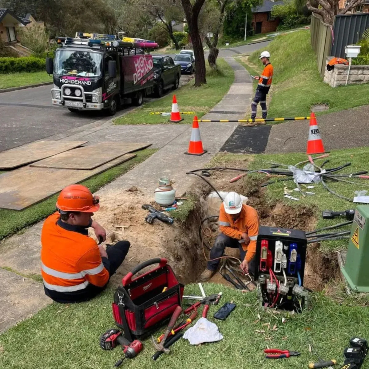 Technicians conducting underground electrical repairs on a suburban street, showcasing High Demand Restoration’s expertise in power restoration and emergency electrical fault repairs.