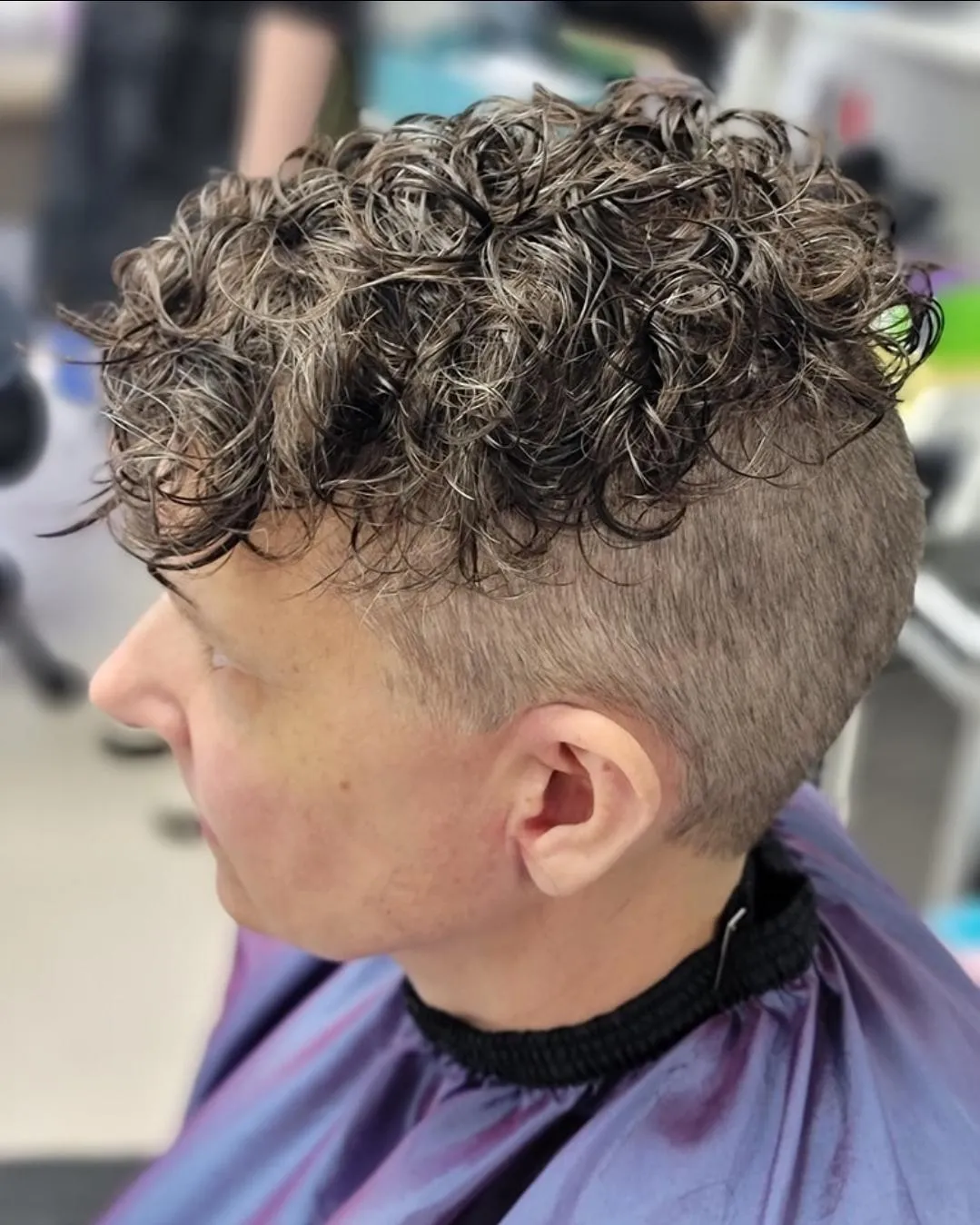 a perm done on brown hair with shaved sides and some length on top