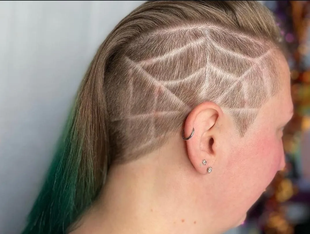 a spiderweb design shaved into the side of the head