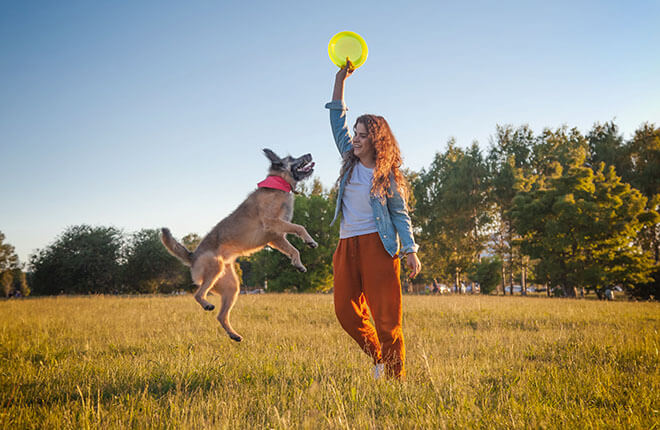 man in blue shirt and blue denim jeans holding woman in white shirt on beach during