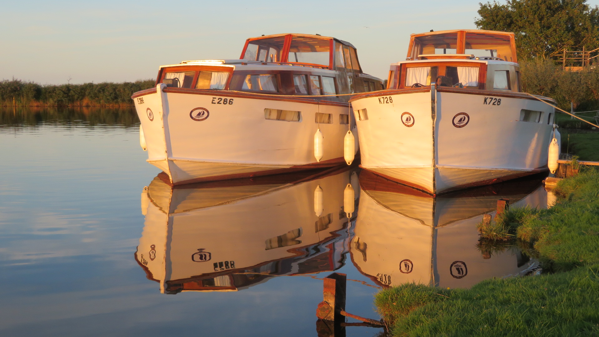 Traditional cruiser boat on the Norfolk Broads at sunset