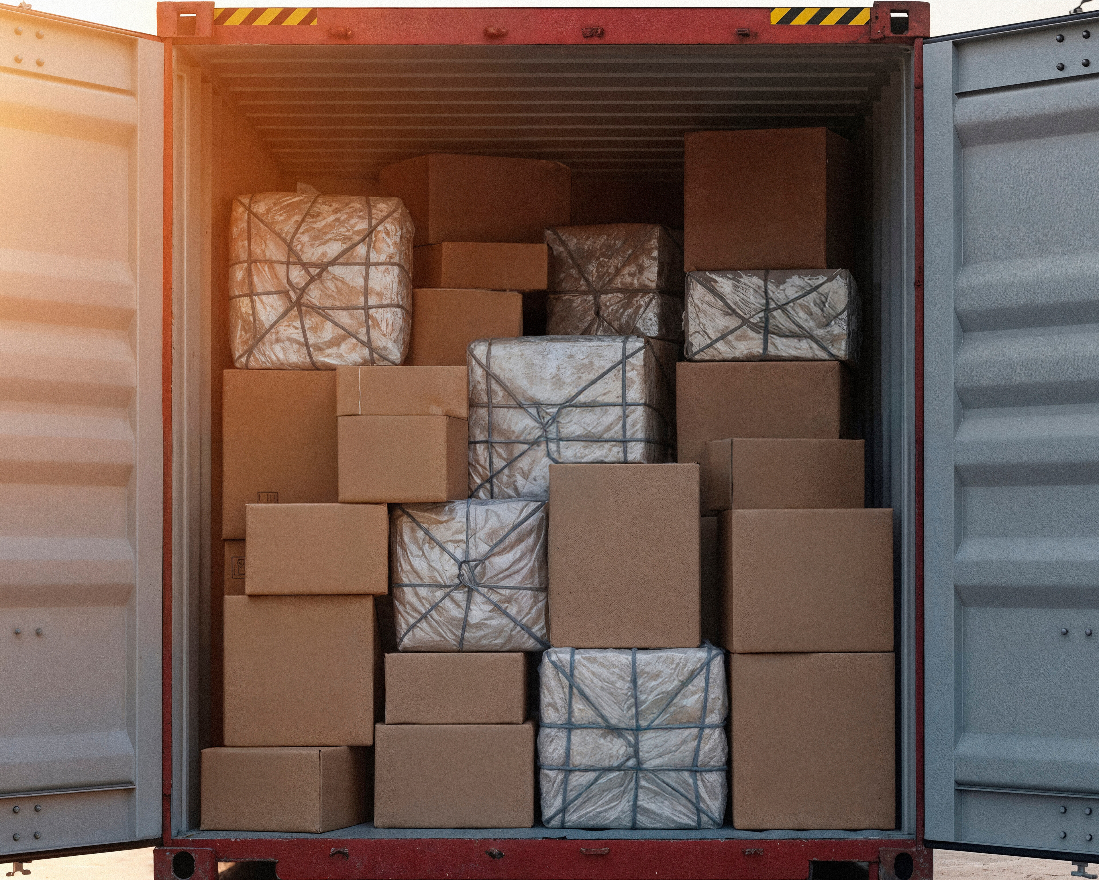 Stacked boxes inside a fully loaded freight container ready for shipment.