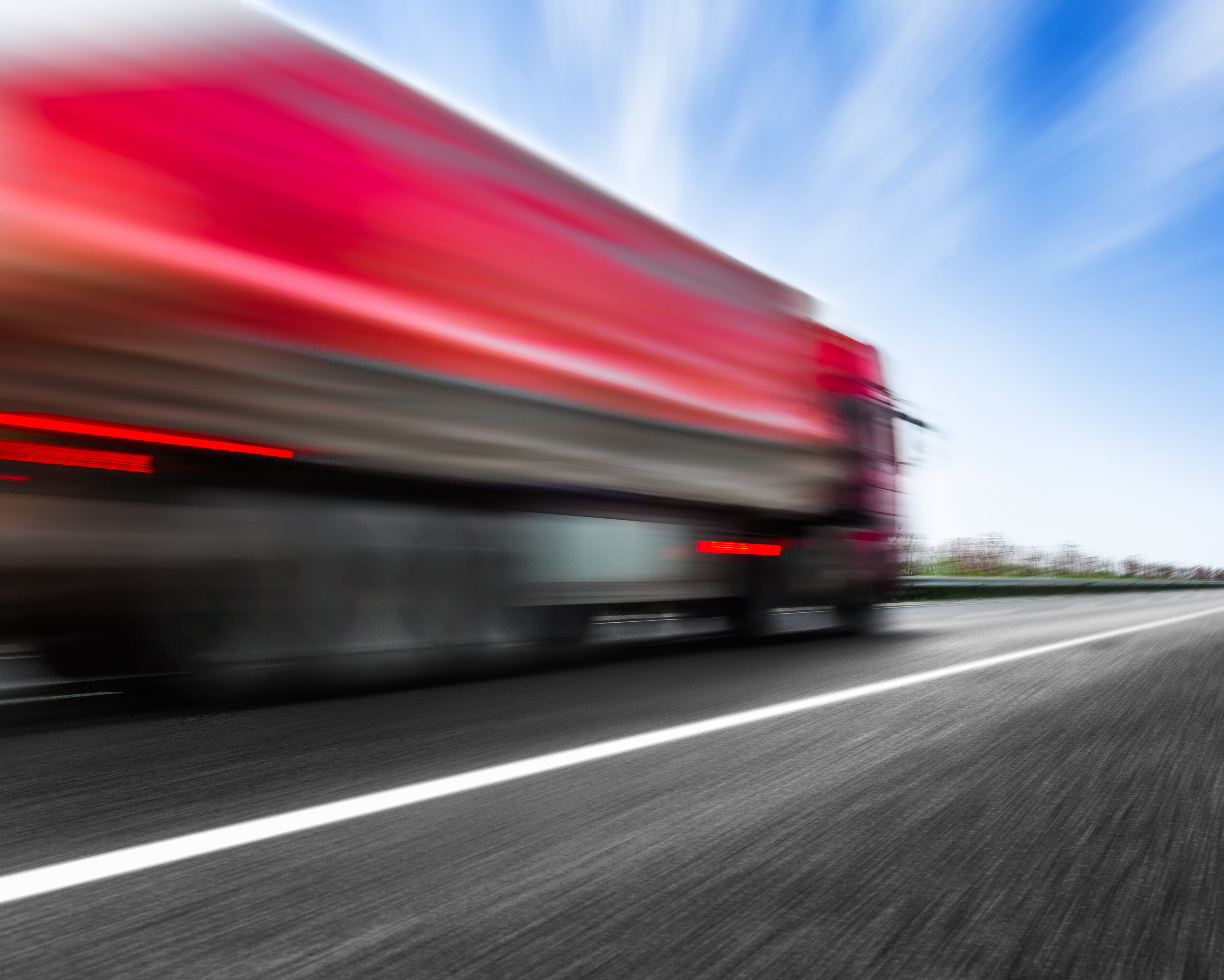 Fast moving truck on a highway creating motion blur to show speed.