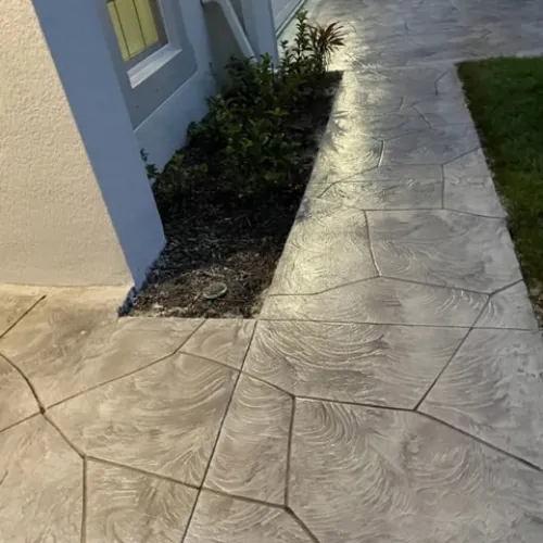 Stamped concrete driveway in Sarasota, FL with stone-like pattern design for residential curb appeal.