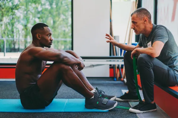 a couple of people walking along a beach next to the ocean