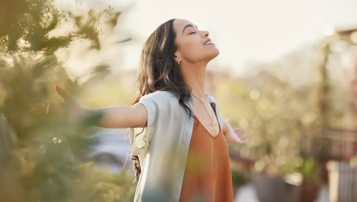 A bright, inviting home studio with yoga mats, fresh fruit, and a journal on a wooden table. Sunlight streams through large windows, creating a peaceful, motivating environment for holistic health practices.