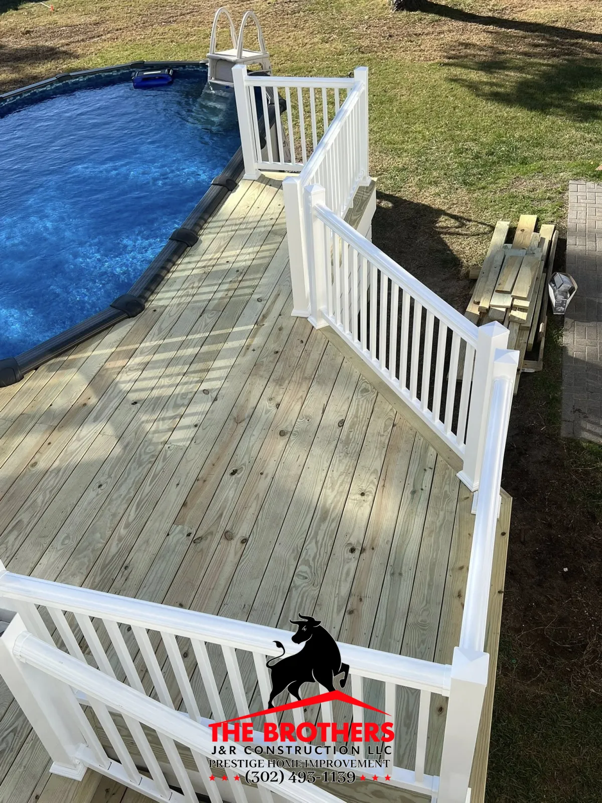 Custom poolside deck with white railing installation in Lewes DE backyard