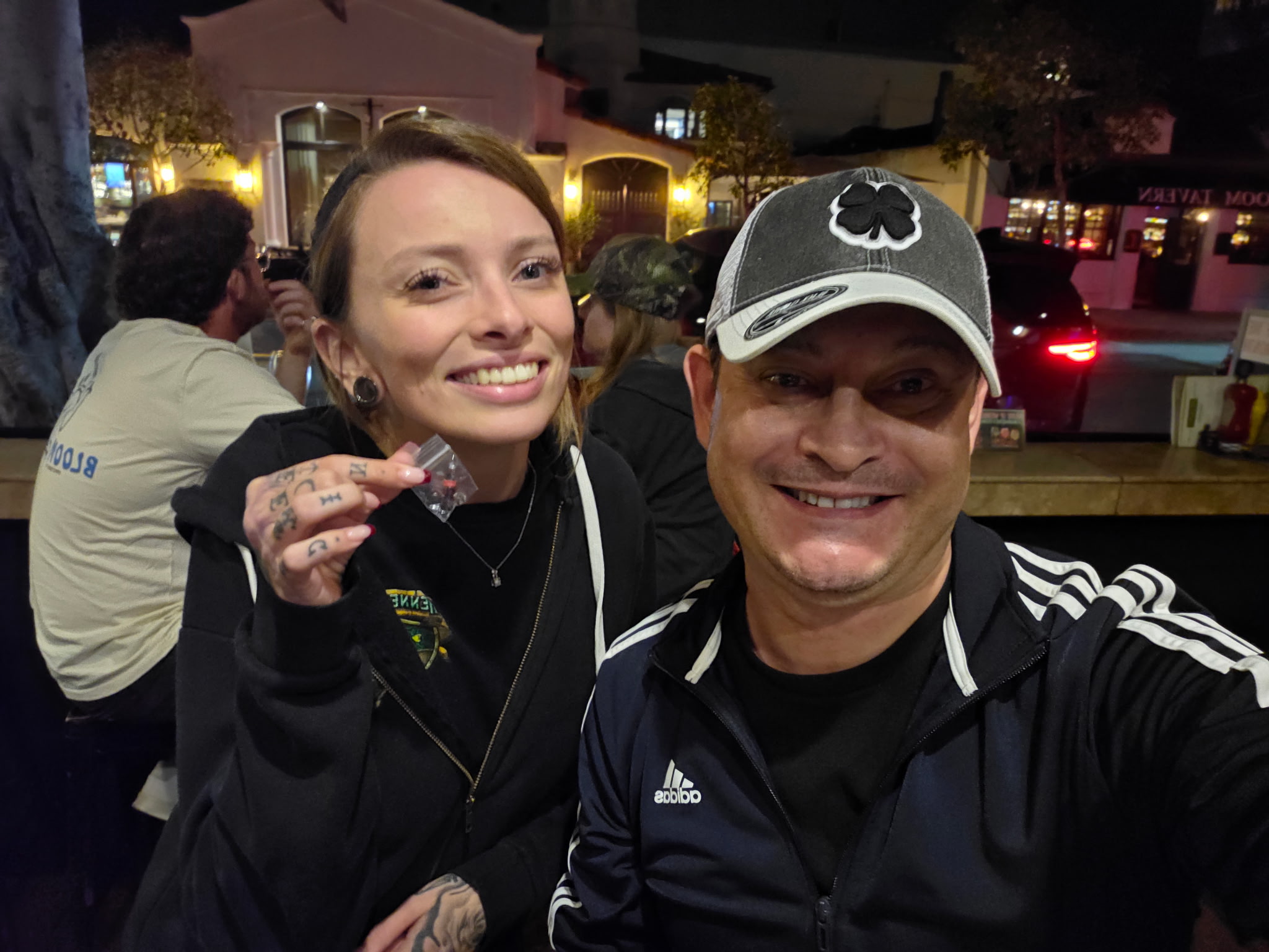 Young woman smiling while taking a selfie outdoors.