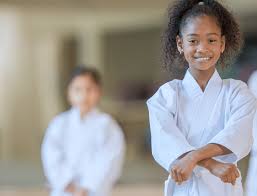 Estudiantes de karate entrenando en un dojo; instructor demostrando una kata
