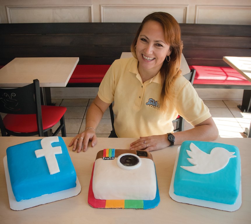 Smiling baker presenting a torta with colorful fillings.