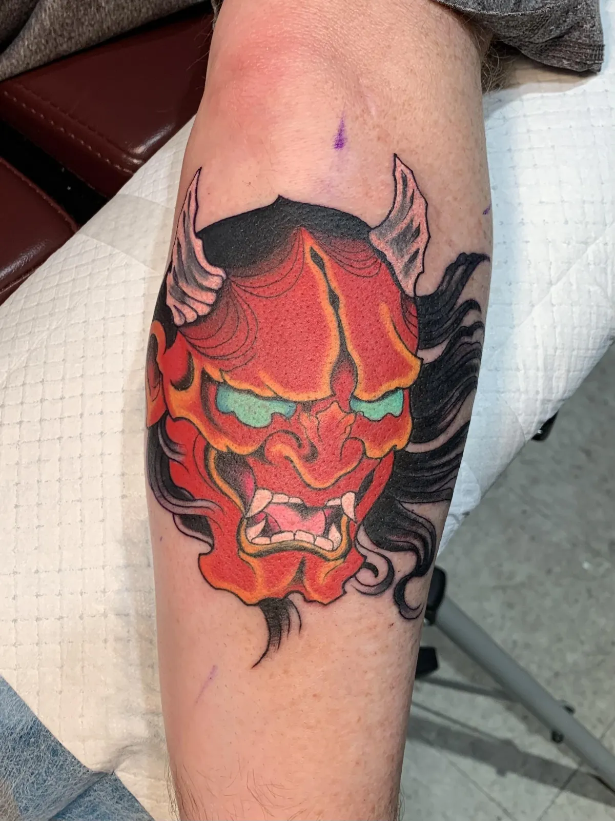 Fine-line botanical sprig on clavicle, delicate single-needle strokes and tiny leaf details; natural light, skin grain visible, intimate square crop highlighting refinement and quiet elegance of small-scale work.