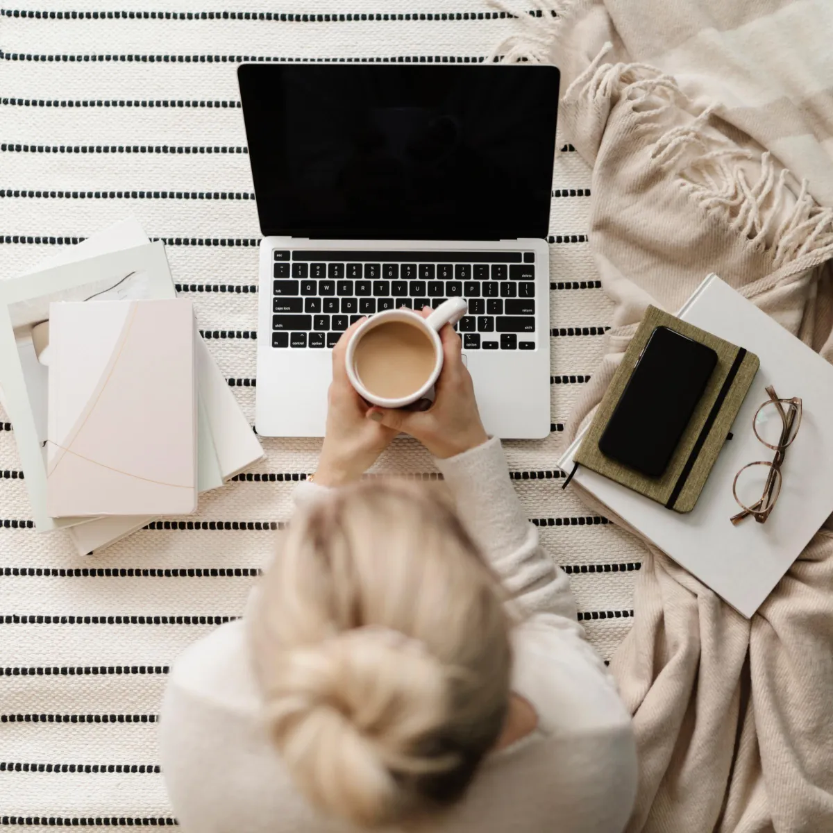 Laptop workspace with coffee mug and cat on desk representing online business planning
