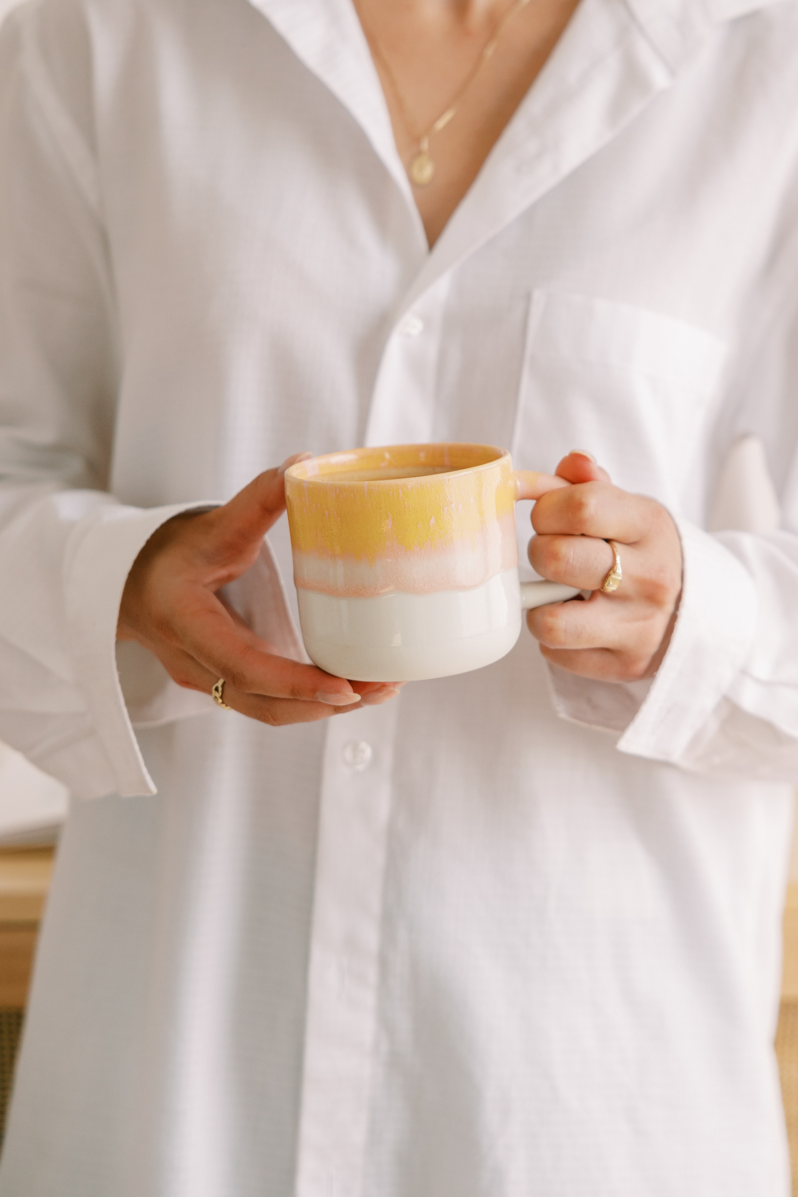 Woman holding a warm drink in a calm moment, representing intentional living, balance, and building a business that fits family life.